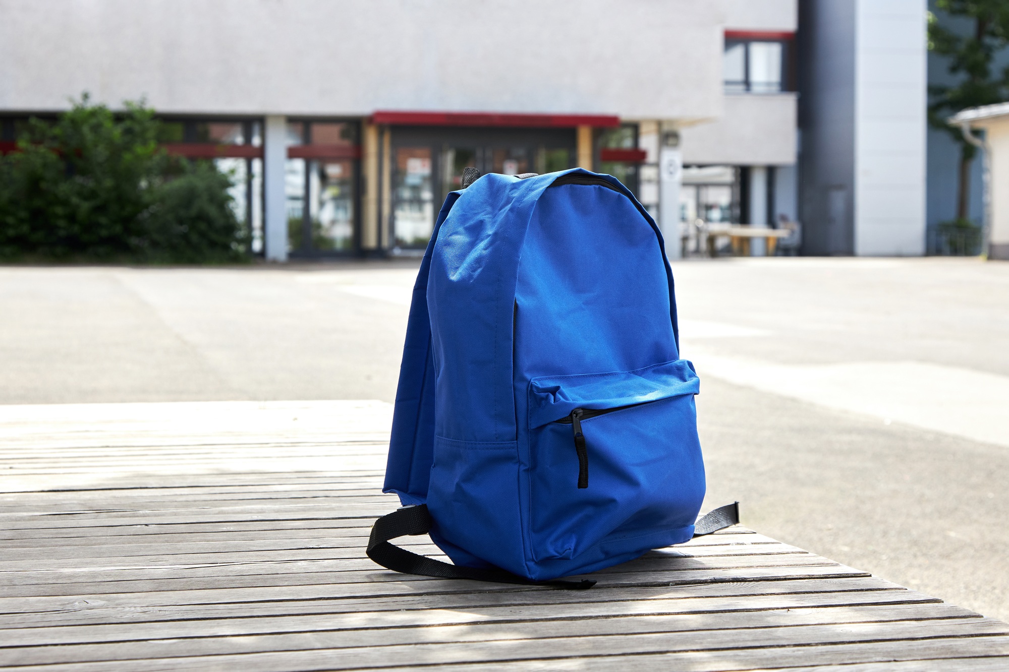 School background. Backpack on a bench